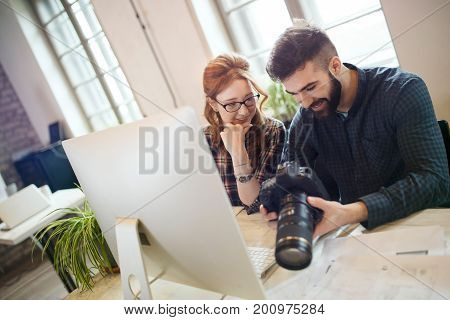 Picture of young attractive designers looking at camera in office