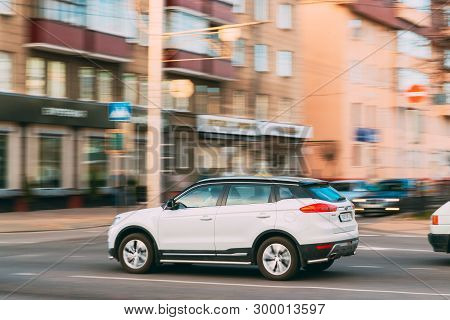Gomel, Belarus - April 16, 2019: White Geely Boyue Geely Atlas Car Fast Rides City Street. Side View