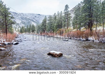 mountain river canyon in springtime snowstorm  - Poudre River in northern Colorado, low angle aerial view