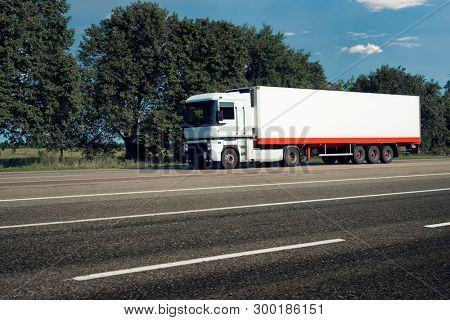 White truck is going up the road. Cargo transportation concept.