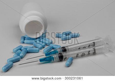 Close Up View Of A Syringe With Hypodermic Needle And Generic Blue Pills. Opiate And Heroin Overdose