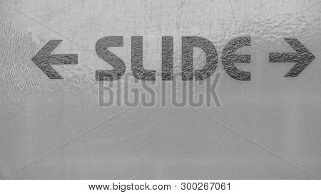 A Word Slide On The Grey Frontdoor With A Direction Arrow Sign On Front Of A Public Bathroom At The 