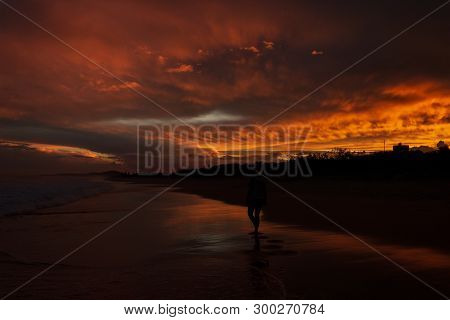 Young Women Walking On Beach With A Colorfull Sunset In The Background At Noosaville Beach, Sunshine
