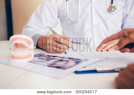 Dentists Are Discussing Dental Problems At Report X-ray Image For Patients.