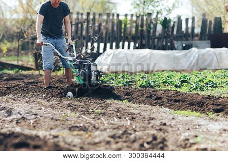 Young Farmer Gardener Cultivate Ground Soil Rototiller , Tiller Tractor, Cutivator, Miiling Machine,