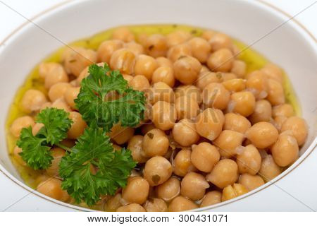 Greek chickpea soup (revithia soupa) garnished with parsley. It's made with olive oil, onion, water, oregano, garlic, bay leaf, lemon juice, flour and seasonings