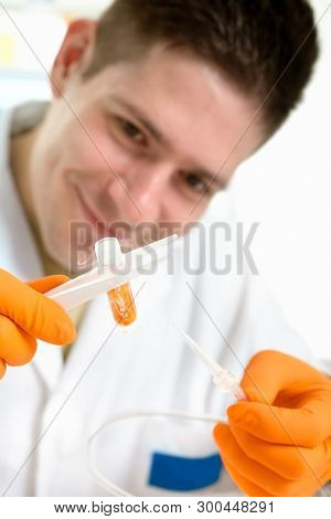 Young Scientist Holds Cryosample In Forceps On White Background