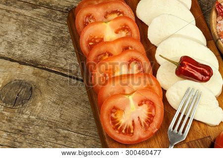 Fresh Mozzarella Cheese And Tomatoes Onkitchen Cutting Board. Healthy Diet Food. Chili Peppers With 