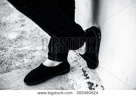 Women Legs Or Female Legs Shod In Black Colored Shoes And Blue Colored Jeans.