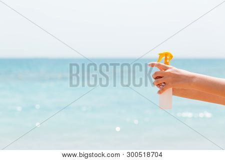 Croped Image Of Womans Hand Holding Sunblock Spray At The Beach