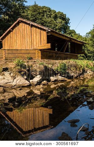 Small Wooden House By The Stream Of A Lake In The Countryside