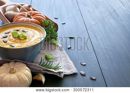 Spicy Pumpkin Creme Soup With Ginger, Onion And Garlic In Ceramic Bowl On The Wooden Table. The Soup
