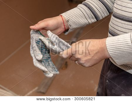 Worker Takes Off Gloves From Hands At A Construction Site.