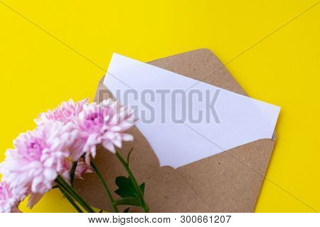 Love Envelope With Blank Letter And Pink Chrysanthemum Flowers On Bright Yellow Bacground. Copy Spac