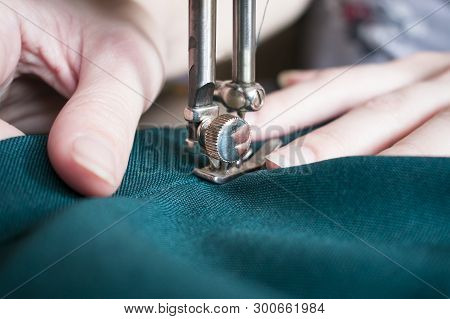 Young Woman On Her Sewing Process, Women's Hands Behind Her Working On Sewing Machine. Closeup Side