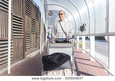 Young Woman Transporting Luggage From Arrival Parking To International Airport Departure Termainal B