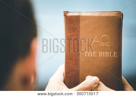 Christian Preacher: Young Man Is Holding The Bible, Praying