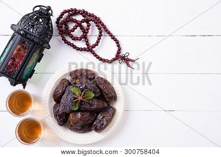 Ramadan Food And Drinks Concept. Ramadan Lantern With Arabian Lamp, Wood Rosary, Tea, Dates Fruit On