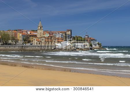 Beautiful Seagull Flies In Stormy Weather Against The Backdrop Of An Ancient City And A Sandy Beach