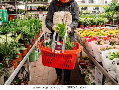 Frankfurt, Germany - Apr 13, 2019: Elegant German Woman Buying Diverse Flowers And Household Carpets