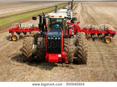 DECABRIST VILLAGE, SARATOV REGION, RUSSIA - 28 APRIL 2019: Sowing works on the wheat field. Planting complex - tractor and seeder mechanism