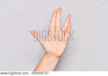 Hand of caucasian young woman greeting doing Vulcan salute, showing hand palm and fingers, freak culture
