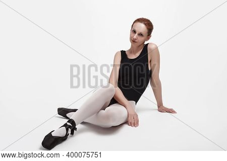 Sport Concepts. Relaxing Professional Ballet Dancer In Body Suit And Pointes Shoes Posing On Floor A
