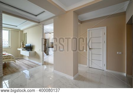 Modern studio apartment with white kitchen in classic style and beige bedroom