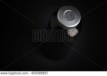 A Macro Shot With Selective Focus Of An Amber Color Vaccine Injection Bottle Set On A Dramatic Black
