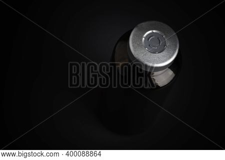 A Macro Shot With Selective Focus Of An Amber Color Vaccine Injection Bottle Set On A Dramatic Black