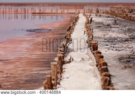 A Fantastic Pink Salt Lake With Salt Crystals On Wooden Pillars On Sunny Day, Kuyalnik Liman In Ukra