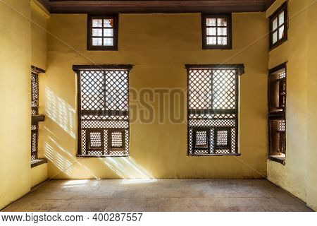 Facade Of Two Interleaved Grunge Wooden Ornate Windows - Mashrabiya - In Stone Wall In Abandoned Bui