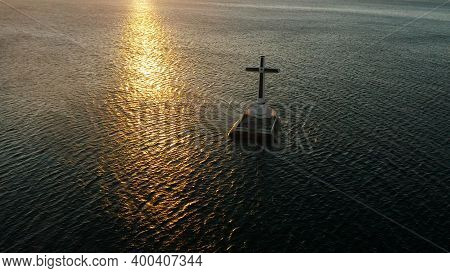 Catholic Cross In Sunken Cemetery In The Sea At Sunset, Aerial Drone. Large Crucafix Marking The Und