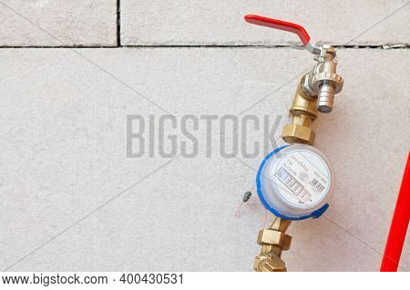 Cold Water Meter With A Tap At The Water Inlet Inside The House On The Background Of Concrete Blocks