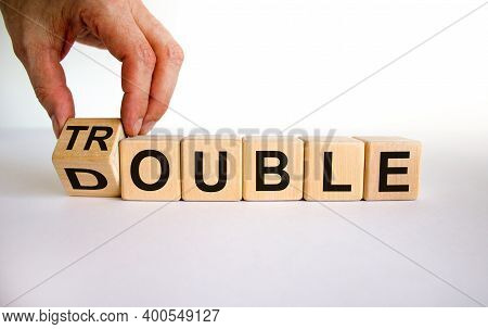 Double Trouble Symbol. Male Hand Flips A Wooden Cube With Words 'double Trouble'. Beautiful White Ba