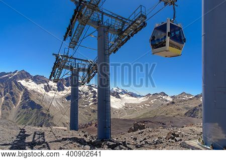 Cable Car Cabin Over A Precipice In The Mountains. Travel By Cable Car In The Caucasus Mountains To 
