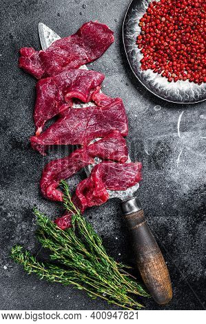 Raw Marbled Meat Cut Into Thin Strips For Beefstroganoff. Black Background. Top View