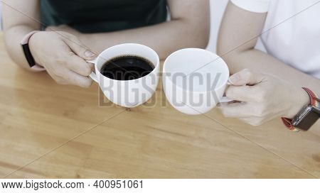 Young Woman Having A Cup Of Coffee Top View.two People Sitting Near Cappucino Coffee Cups On Table

