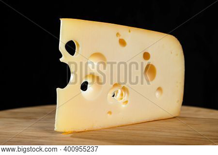Yellow Cow's Milk Swiss Cheese Emmenthal With Holes On Wooden Board.
