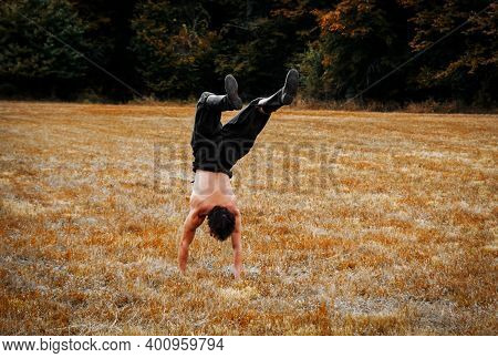 Young Man Xercising In Nature. Autumnal Field.
