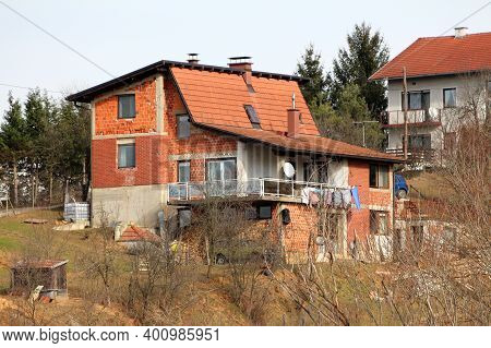 Unfinished Red Building Block Suburban Family House With Large Open Balcony In Front And Unusually S