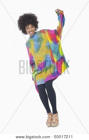 Full length portrait of an African American woman in dashiki standing over gray background