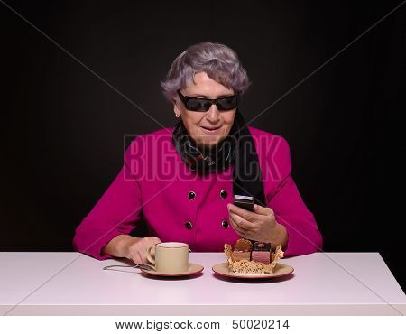 Gray-haired lady dialing on a mobile phone