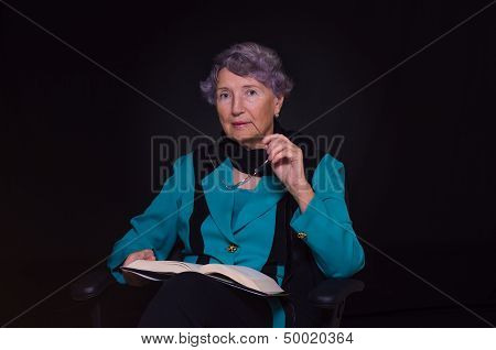 Old woman chews the handle of glasses