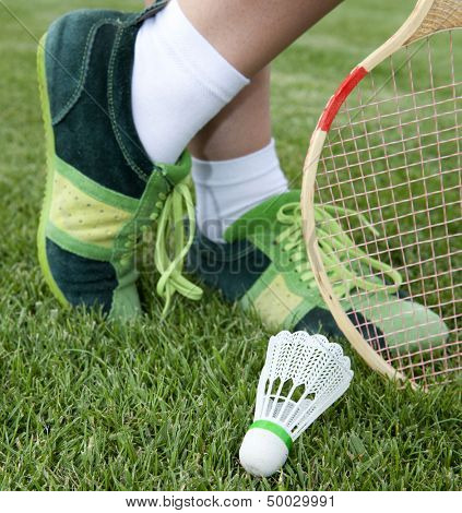 foot of sportswoman who plays badminton on grass