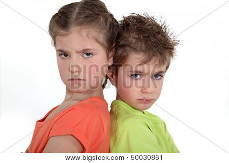 Brother and sister sulking at each other.