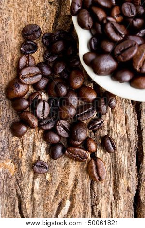 Coffee Beans In White Cup On Wooden Background.