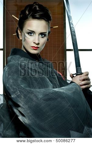 beautiful japanese grey kimono woman with samurai sword in traditional room