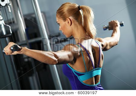 Image of fitness girl in gym exercising with dumbbells