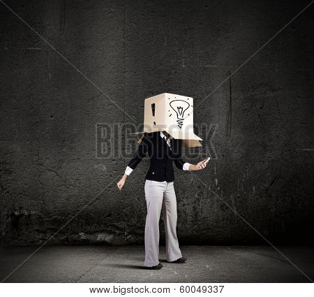 Businesswoman using mobile phone wearing carton box on head